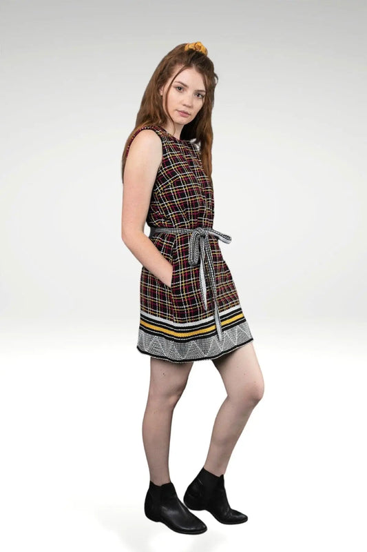 side view of the model wearing the BELLA EMBROIDERED SHIFT DRESS with allover thread embroidery on black twill base