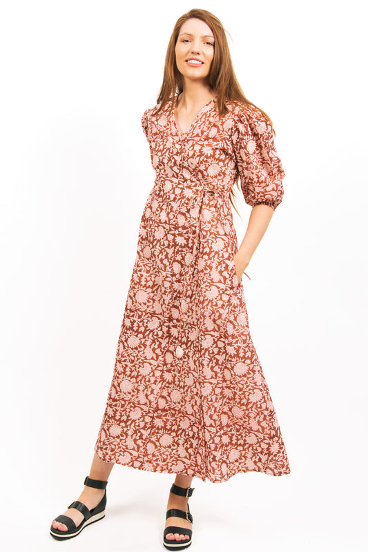MODEL WEARING ZEPHYR BLOCK PRINT WRAP MAXI DRESS IN AMBER BROWN COLOUR WITH HANDS IN POCKETS- zohaonline