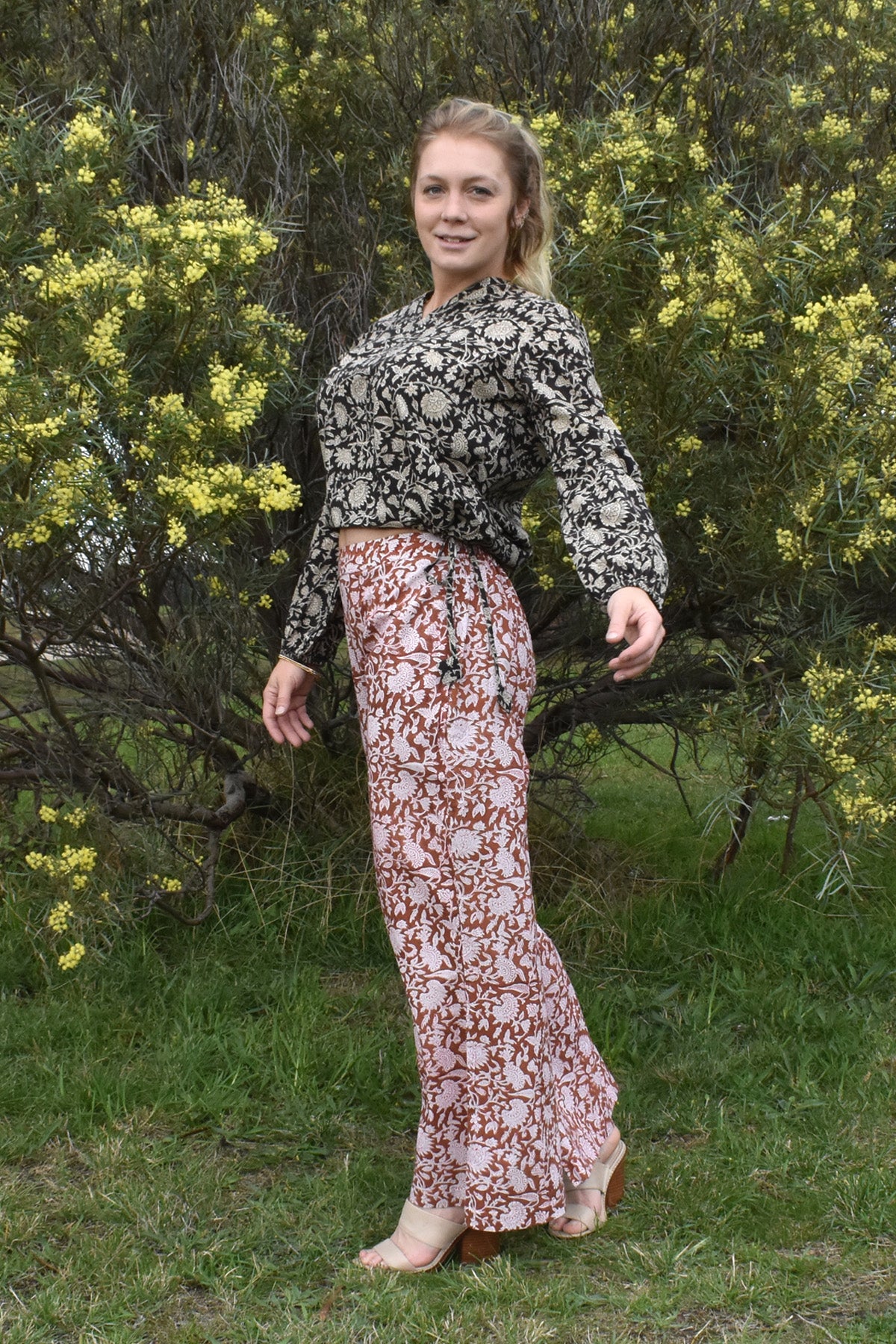 MODEL WEARING AMBER FLARE PANTS WITH SABLE TOP IN NATURE SETTING - zohaonline