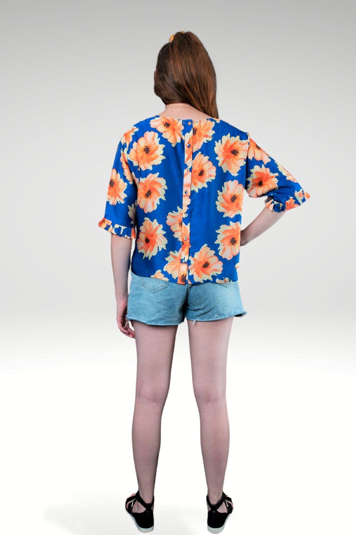 back view of blue LARA FLORAL TOP with back button opening worn with denim shorts - zohaonline